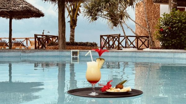 Cocktail served at the pool edge with ocean backdrop